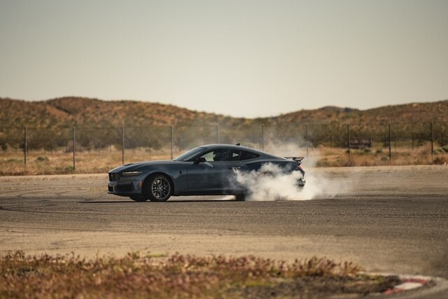 2024 Ford Mustang® Dark Horse™ coupe in Vapor Blue Metallic with a driver performing burnouts on a closed course