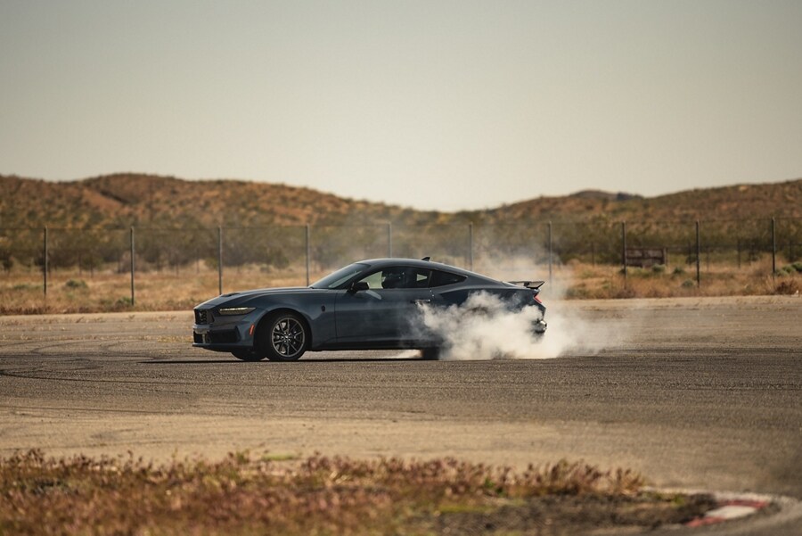 2024 Ford Mustang® Dark Horse™ coupe in Vapor Blue Metallic with a driver performing burnouts on a closed course