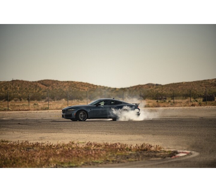 2024 Ford Mustang® Dark Horse™ model with a driver performing burnouts on a closed course