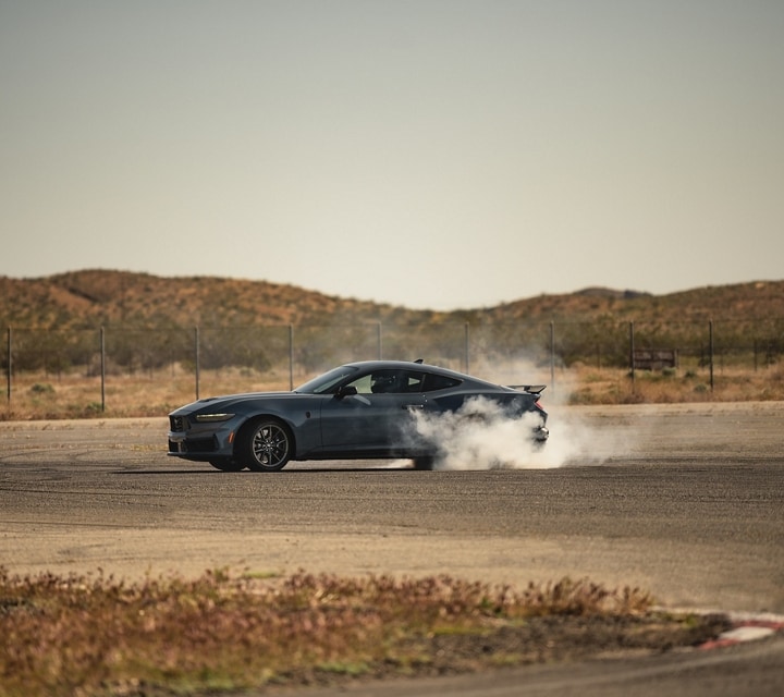 2024 Ford Mustang® Dark Horse™ model with a driver performing burnouts on a closed course