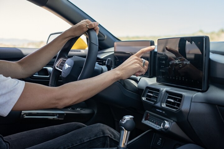 Driver using the 2024 Ford Mustang® touchscreen