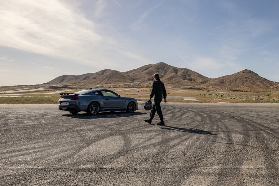 Person approaching a 2024 Ford Mustang® Dark Horse™ coupe parked on a closed course