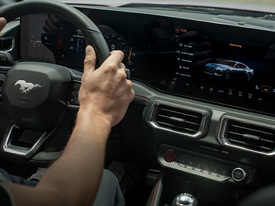 2024 Ford Mustang® interior with driver's hands on a flat-bottom steering wheel