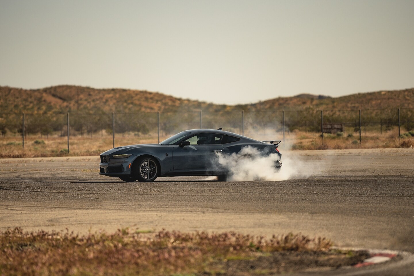 2025 Ford Mustang doing a burnout in parking lot.