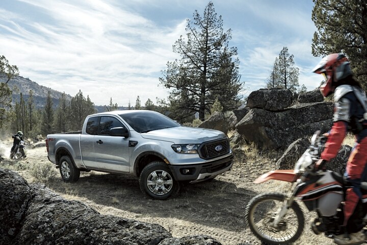 2022 Ford Ranger being driven off road with dirt bikes to the front and rear
