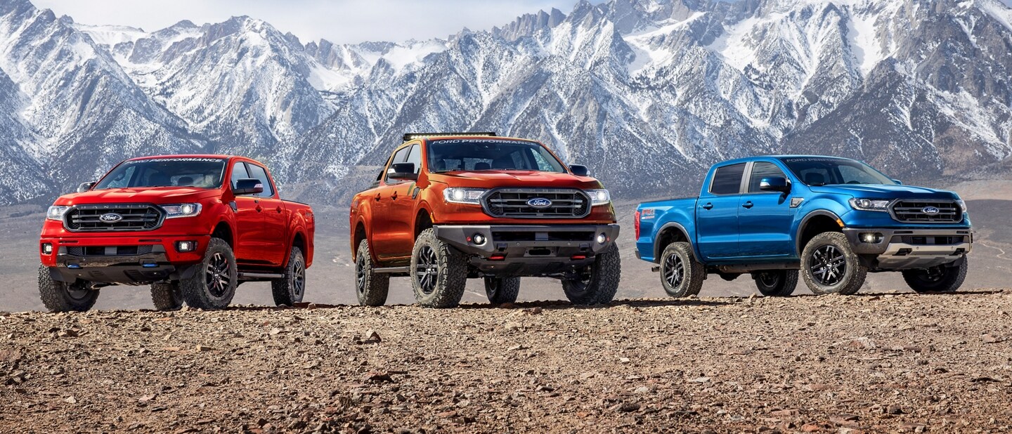 Tres Ford Rangers 2022 con Piezas de Desempeño Ford instaladas, estacionadas en frente de una montaña nevada