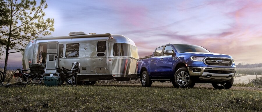 2023 Ford Ranger® in Velocity Blue parked at a campsite with a trailer attached