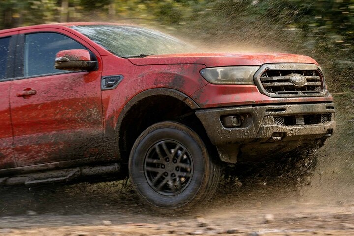 Una Ford Ranger Tremor Lariat 2023 en Hot Pepper Red andando por el lodo