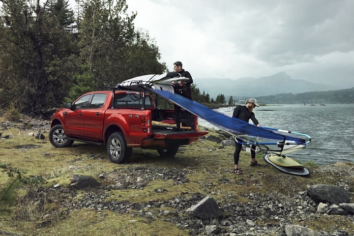 Se muestra una Ford Ranger® FX4 SuperCrew® 2023 en Hot Pepper Metallic cargada con un equipo de surf