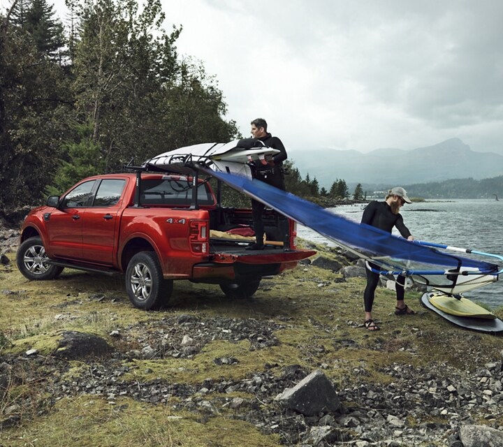 Se muestra una Ford Ranger® FX4 SuperCrew® 2023 en Hot Pepper Metallic cargada con un equipo de surf