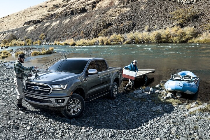 Ford Ranger 2023 estacionada en la ribera de un río con hombres cargando equipos de pesca