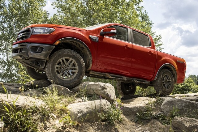 Una Ford Ranger 2023 en Race Red con el Paquete para Todo Terreno Tremor® circulando por un camino rocoso