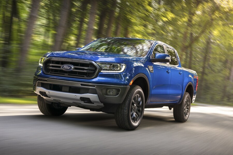 Se muestra una Ford Ranger 2023 en Velocity Blue descendiendo por una carretera de dos carriles