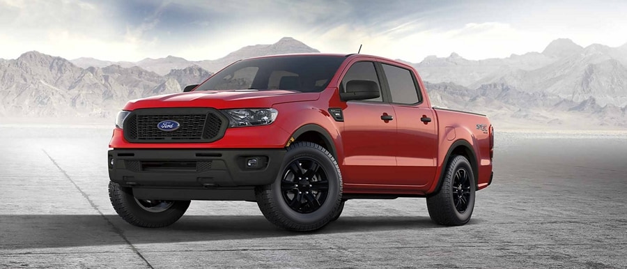 Una Ford Ranger® 2023 en Race Red con el Paquete de Apariencia STX estacionada cerca de unas montañas
