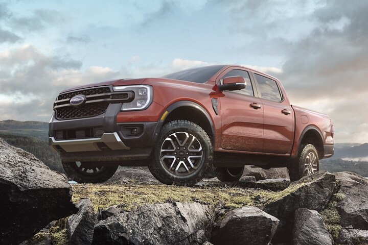 A 2024 Ford Ranger® LARIAT® in Hot Pepper Red extra cost color on a rocky ledge