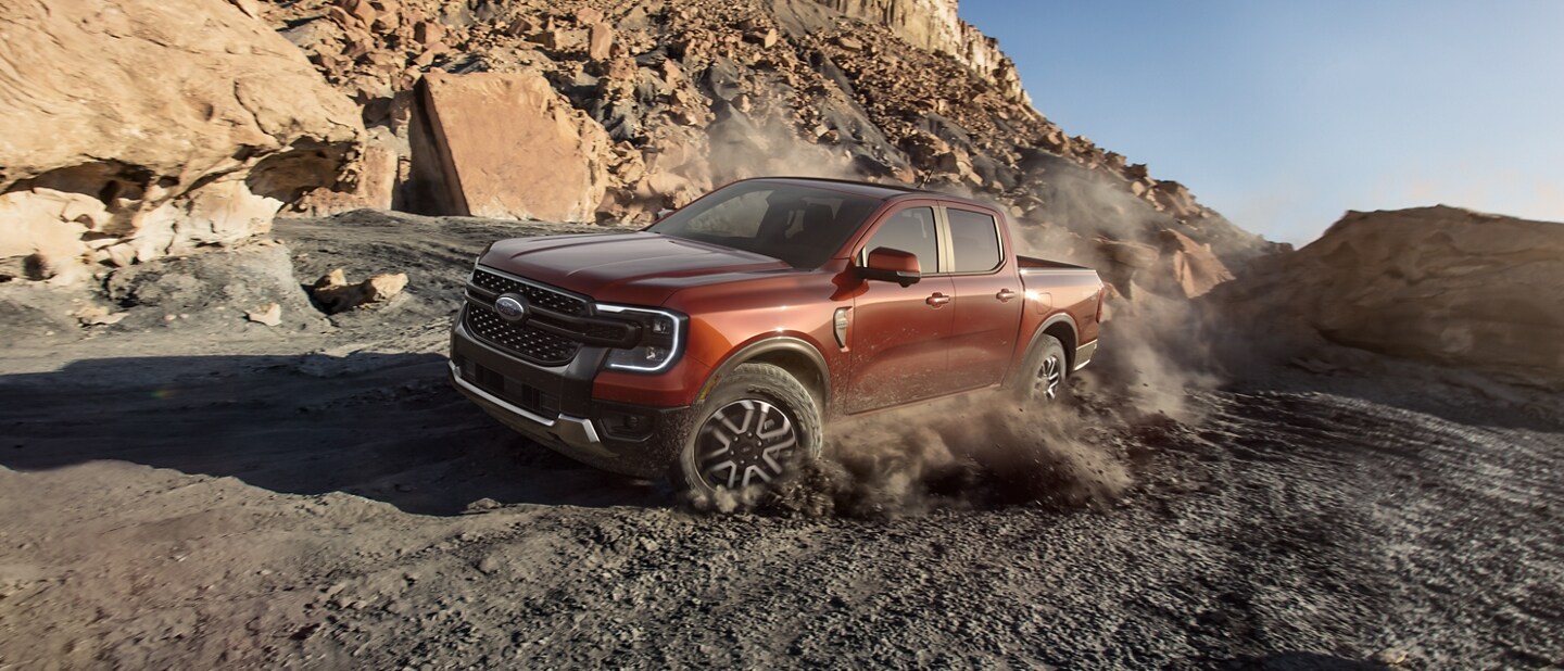 A 2024 Ford Ranger® truck in Hot Pepper Red is being driven off-road in a scenic location
