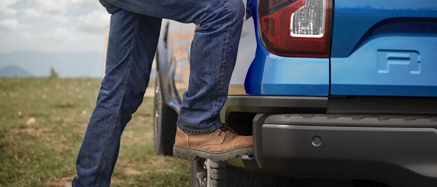 A 2024 Ford Ranger® in Velocity Blue with the Boxside Step being demonstrated by a person