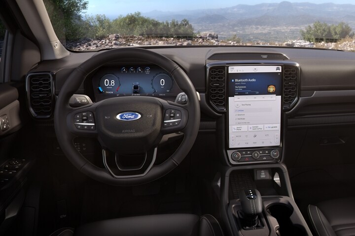 The interior of a 2024 Ford Ranger® steering wheel and center stack screen with a view of the outside