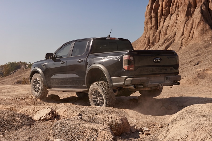 A 2024 Ford Ranger® in Shelter Green parked on a sand dune with a close-up of the grille