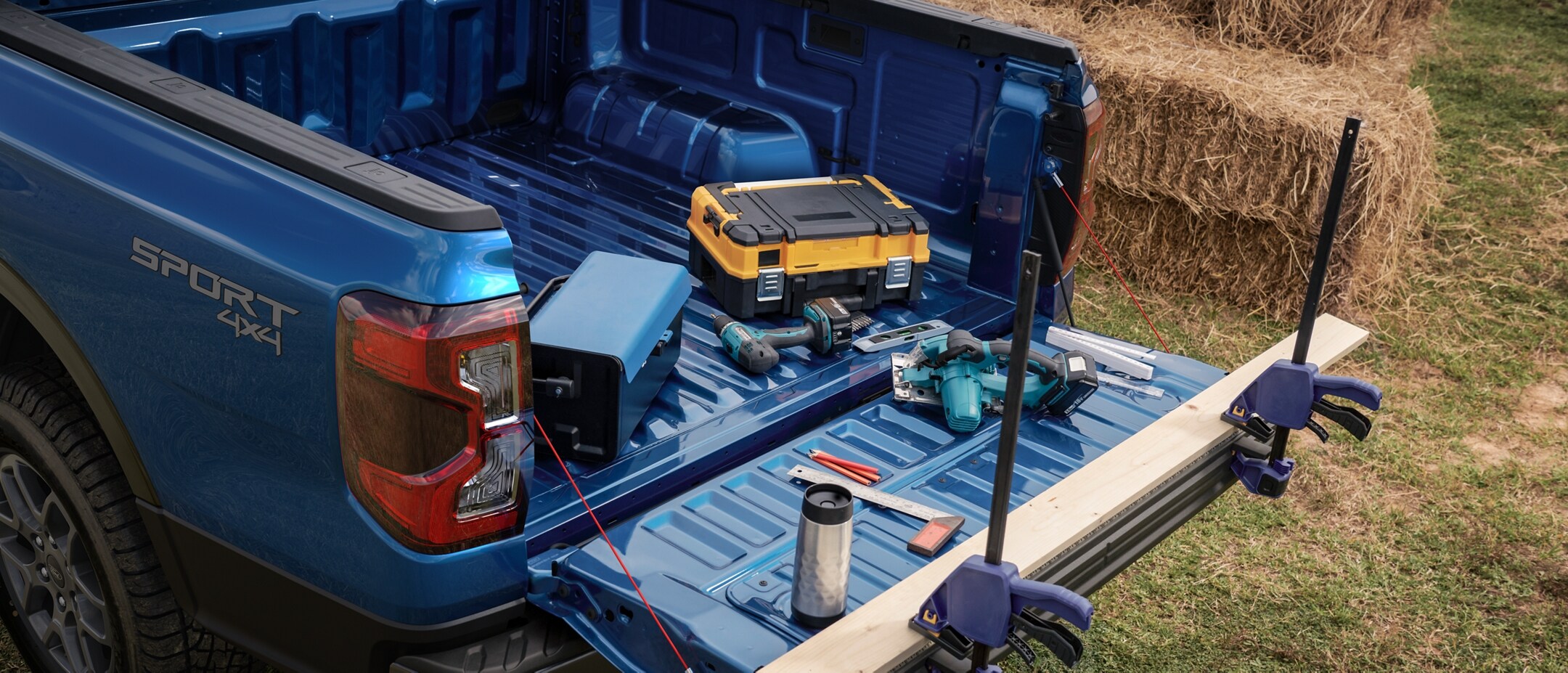 A 2024 Ford Ranger® truck in Velocity Blue with the tailgate work platform being used to chop wood