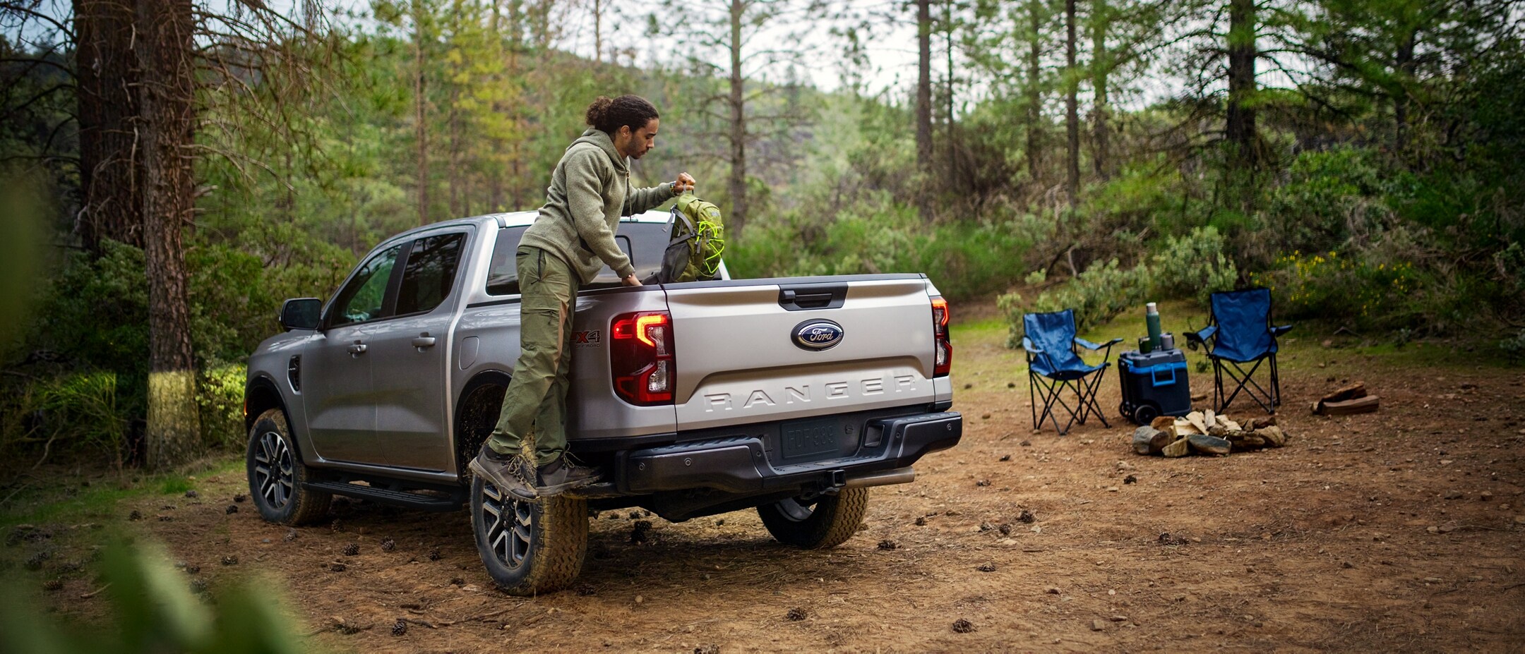 A 2024 Ford Ranger® is in a scenic location with a person loading cargo with the Integrated Boxside Step