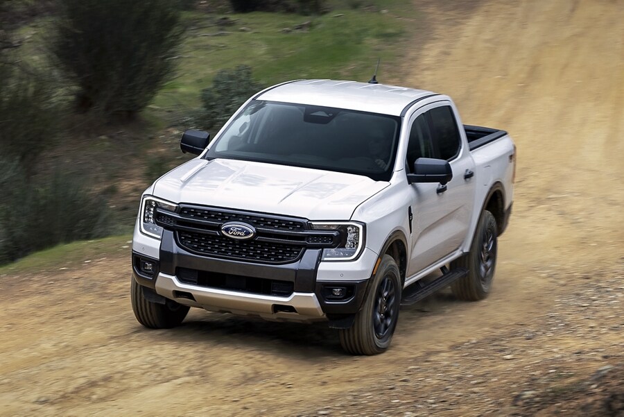 A 2024 Ford Ranger® is being driven on a dirt road in a scenic location