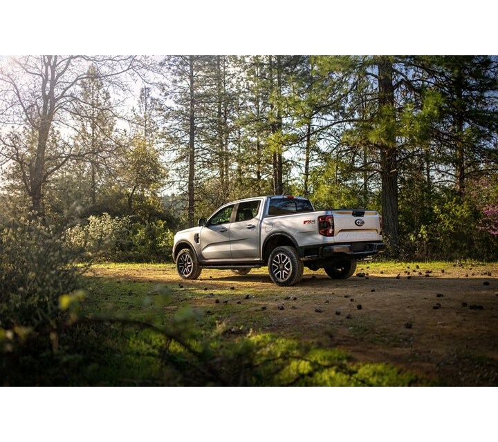 A 2024 Ford Ranger® in Oxford White parked on a dirt road with trees