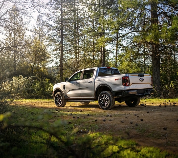 A 2024 Ford Ranger® in Oxford White parked on a dirt road with trees