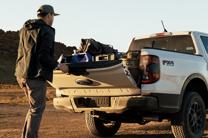 A 2024 Ford Ranger® XLT in Oxford White with the FX4® Package with cargo being loaded on mountain