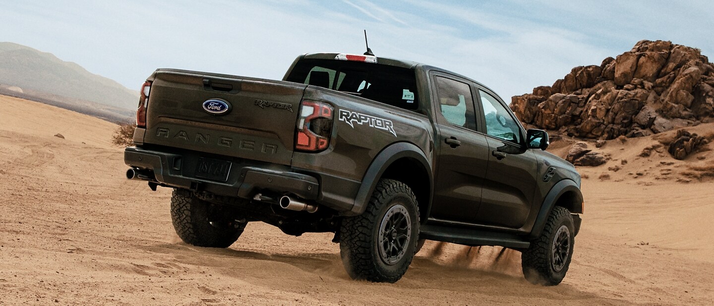 A 2024 Ford Ranger® Raptor® in Shelter Green being driven off-road in the hills