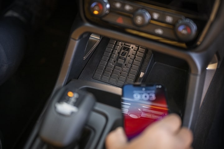 Close-up of a person's hand putting their cellular phone on the wireless charging pad of a 2024 Ford Ranger®