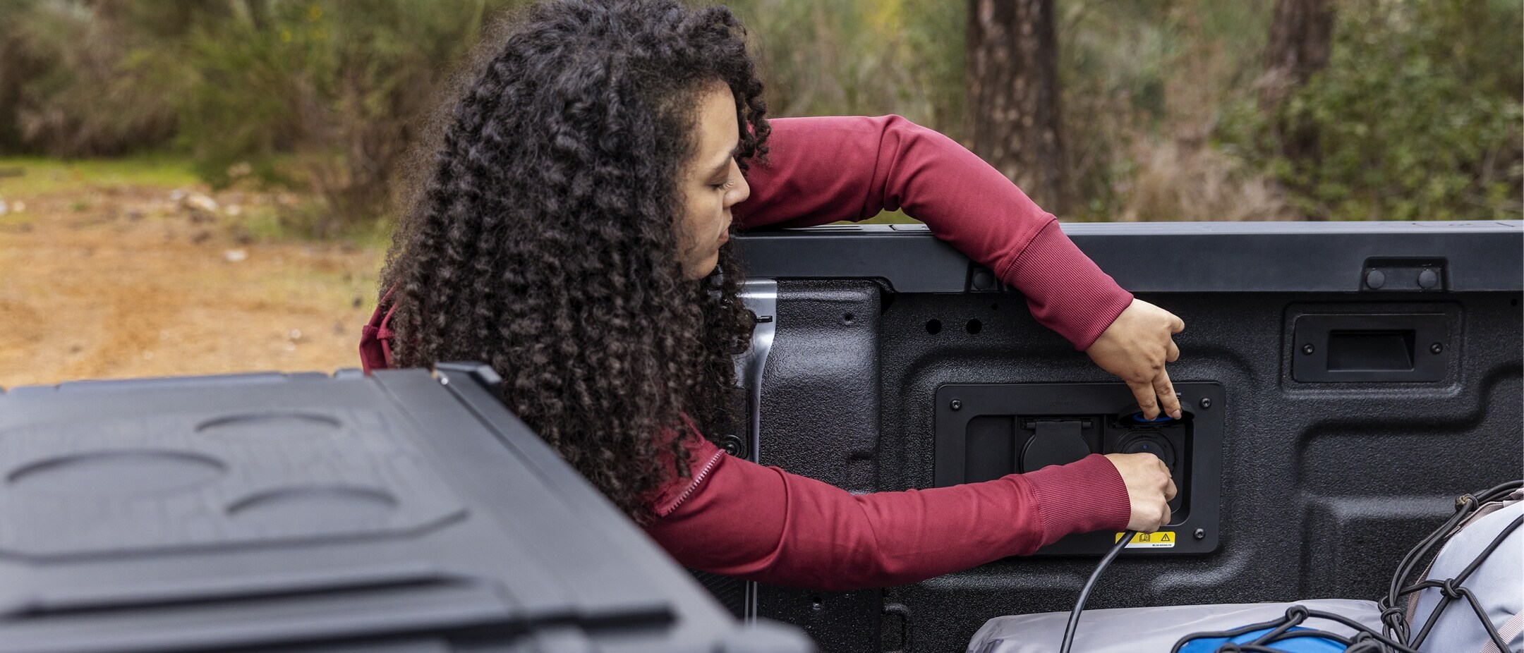 A person is using the 400-Watt outlet in their parked 2024 Ford Ranger® truck bed