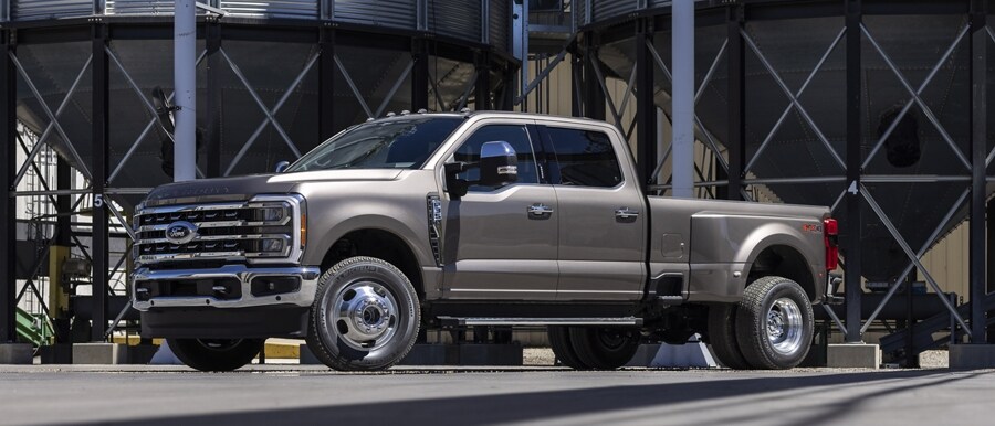 Un modelo de la Ford Super Duty® F-350® LARIAT® 2023 estacionada cerca de un silo de granos