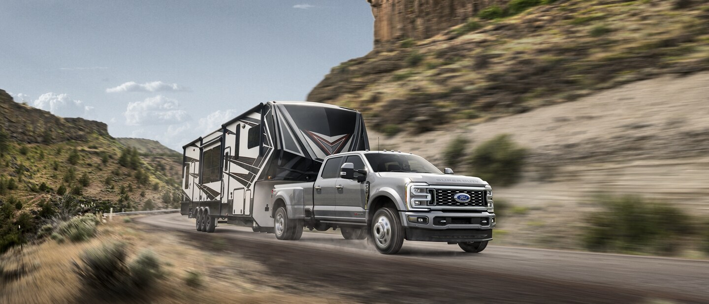 2023 Ford Super Duty® F-450® Limited pulling a camper trailer on a mountain roadway