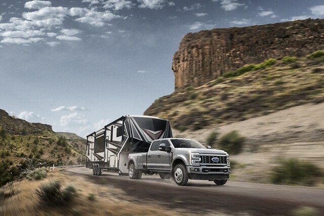 2023 Ford Super Duty® F-450® Limited pulling a camper trailer on a mountain roadway
