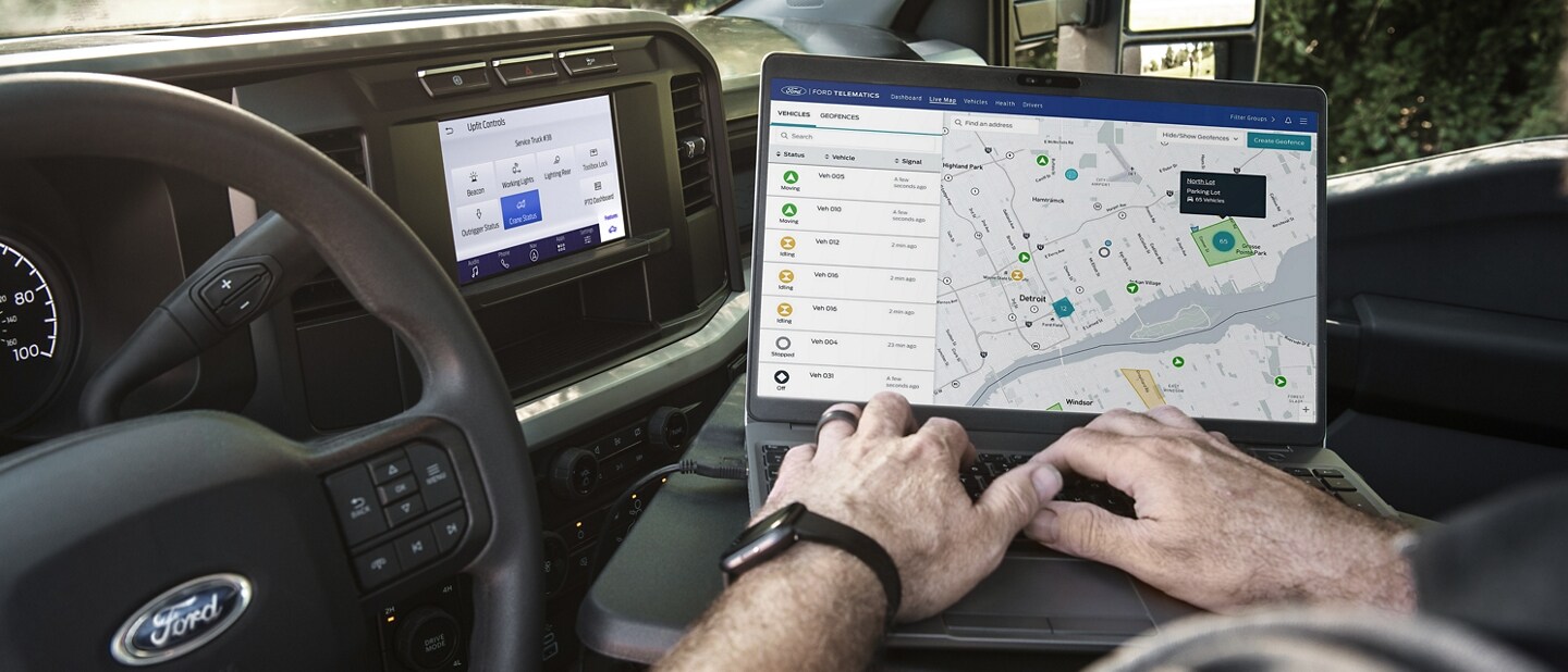 Close-up of a man using a laptop computer inside a 2023 Ford Super Duty® truck