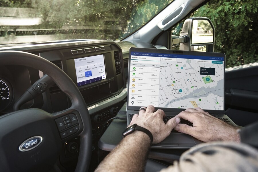 Close-up of a man using a laptop computer inside a 2023 Ford Super Duty® truck