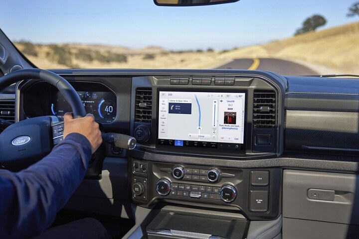 Una mujer en el asiento del conductor en una Ford Super Duty® 2023 donde se muestra una pantalla grande