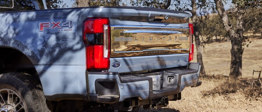 Primer plano de un modelo de Ford Super Duty® Limited 2023 que destaca los escalones en la defensa trasera y la puerta trasera grabada