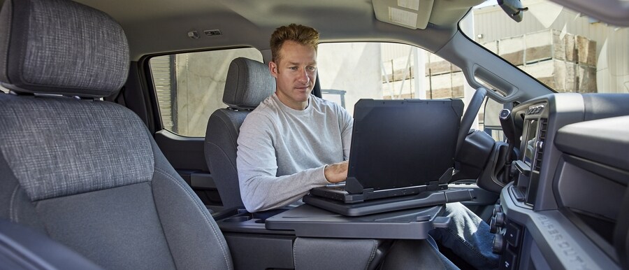 Un hombre usando una computadora portátil en el interior de una camioneta Ford Super Duty® 2023