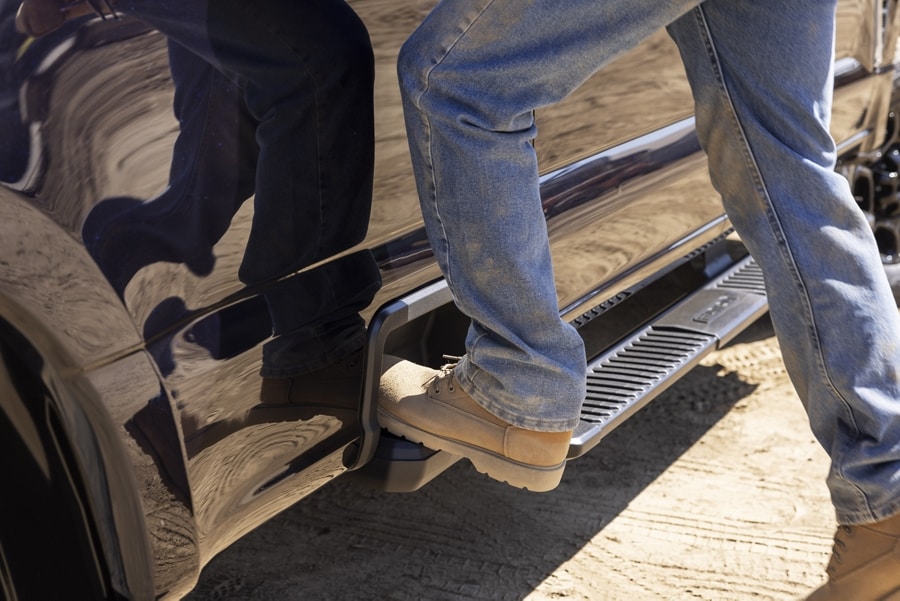 Close-Up of a worker's boot stepping inside the integrated box side step of a 2024 Ford Super Duty® pickup
