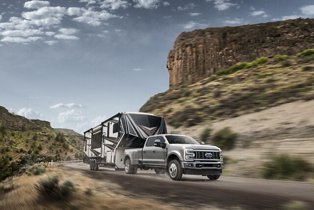 2024 Ford Super Duty® F-450® Limited pulling a camper trailer on a mountain roadway