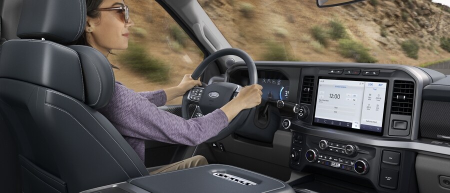 Woman driving with the 12-inch display screen showing SYNC® 4 features
