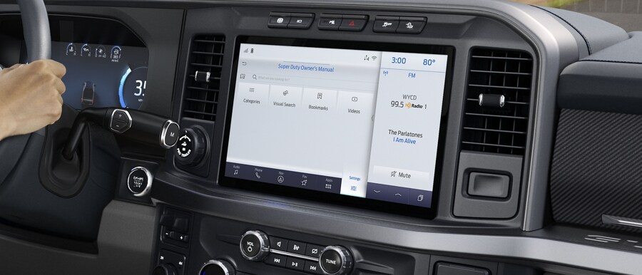 Woman driving with center stack screen showing the Digital Owner’s Manual in a 2024 Ford Super Duty® truck