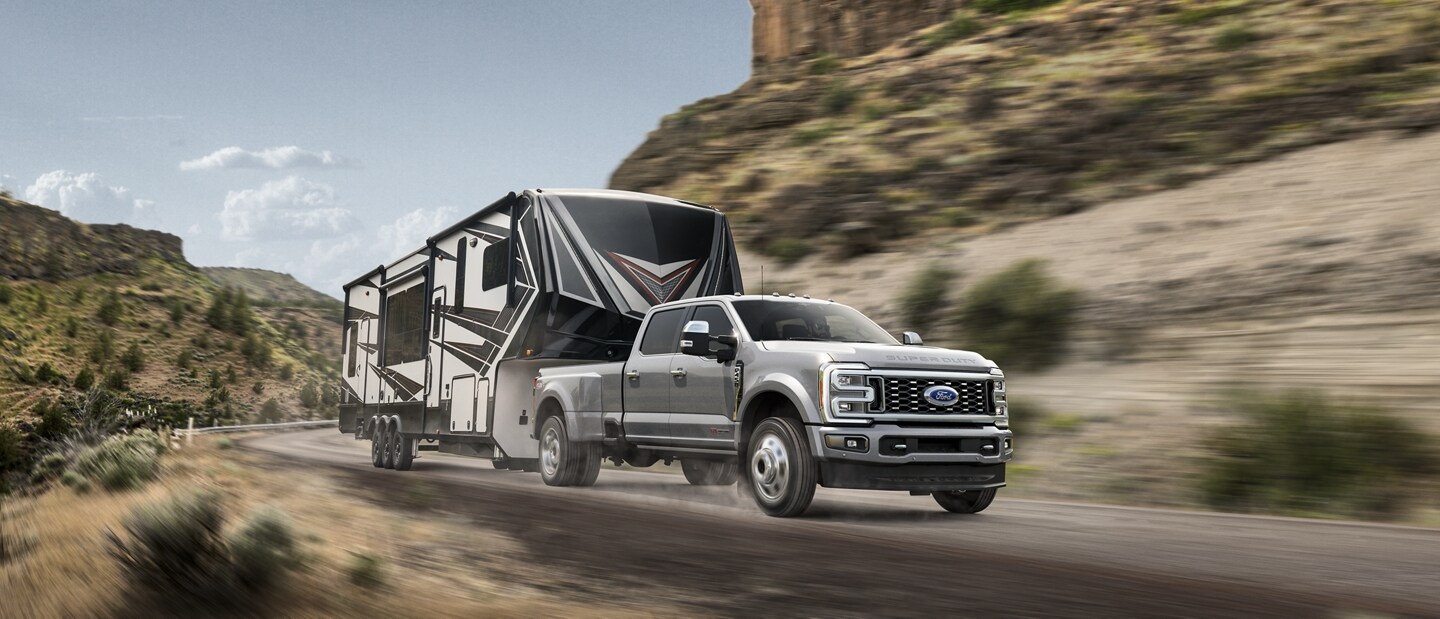 2024 Ford Super Duty® F-450® Limited pulling a camper trailer on a mountain roadway