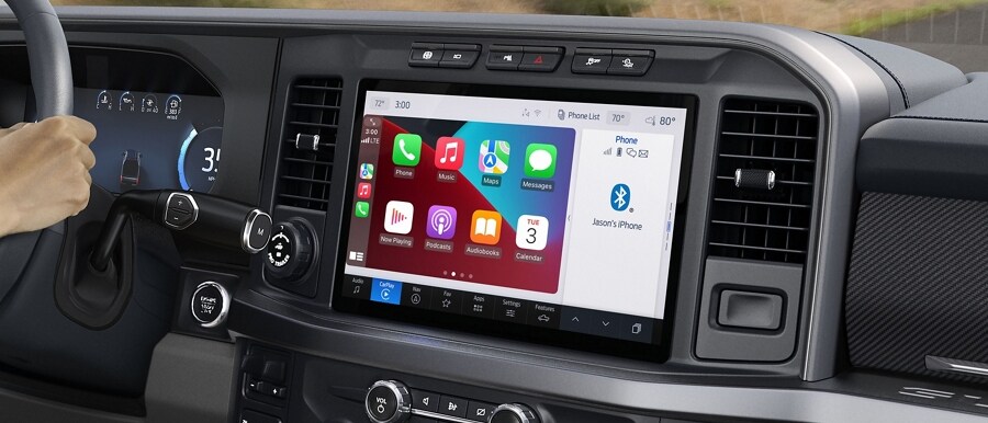 Woman driving with the 12-inch display screen showing Apple CarPlay Applications