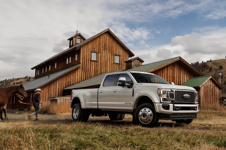 2021 Ford Super Duty F 4 50 Limited Crew Cab in Star White Metallic on a farm with farmer and horse in the background