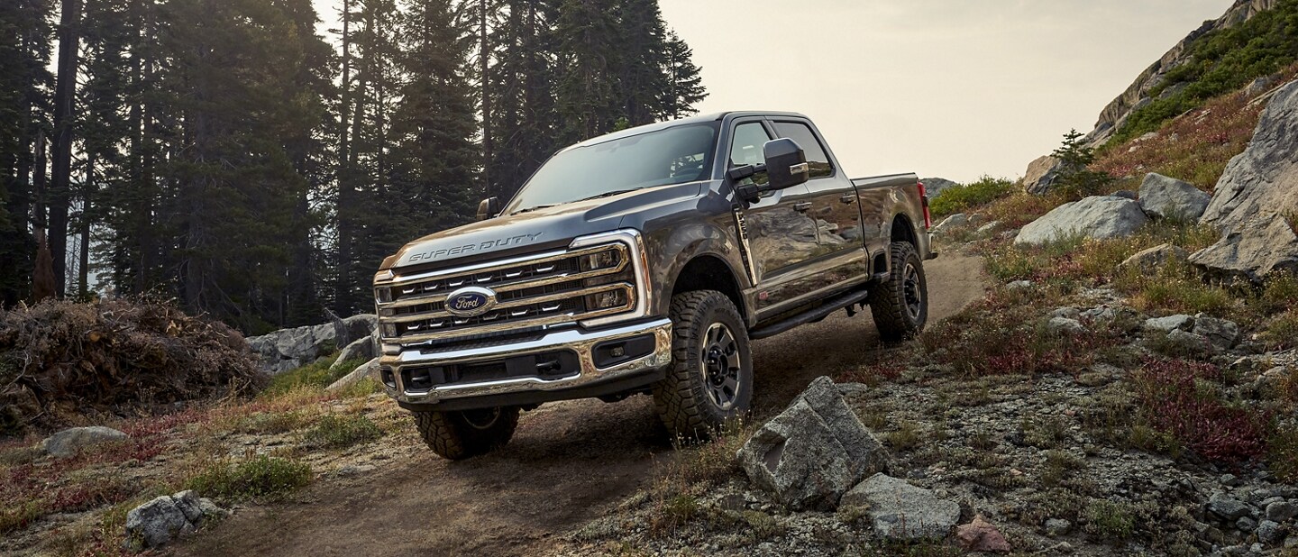Una Ford Super Duty® F-250® 2023 con Paquete Todo Terreno Tremor® andando por un camino rocoso