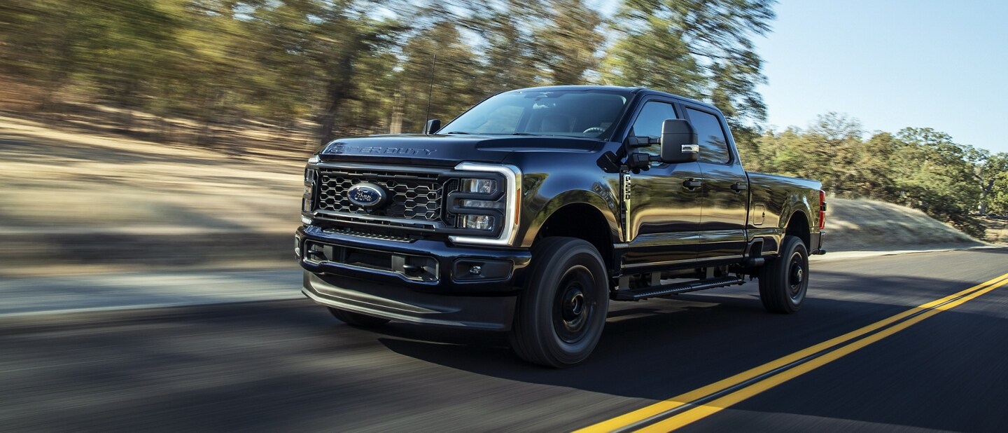 Una Ford Super Duty® F-250® XL 2023 con Paquete de Apariencia STX andando por una pintoresca carretera