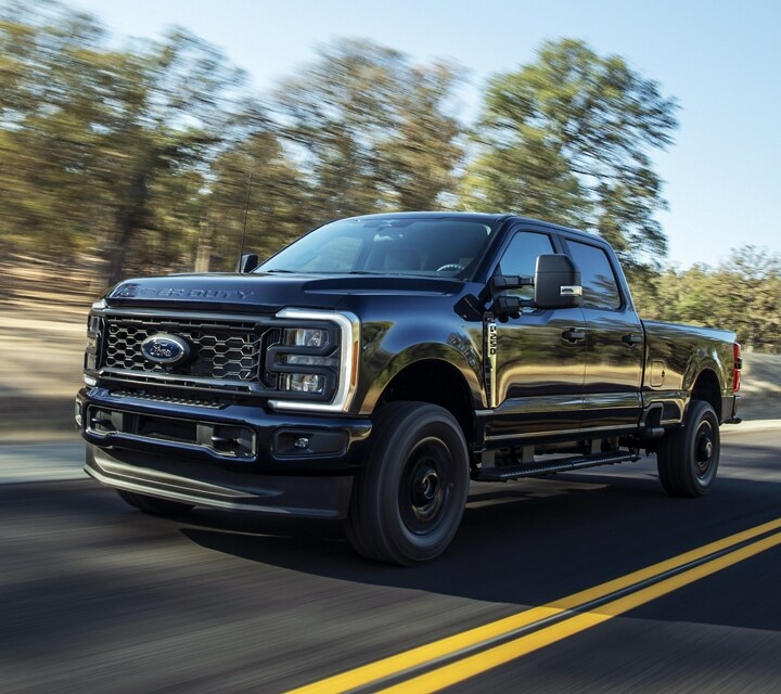 Una Ford Super Duty® F-250® XL 2023 con Paquete de Apariencia STX andando por un camino